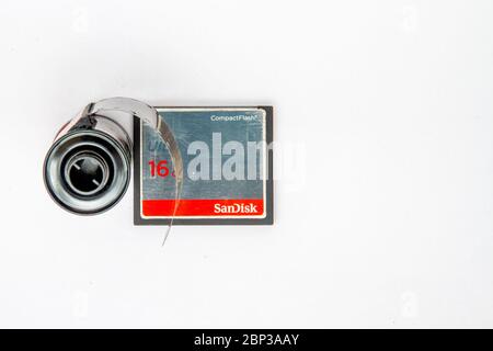 overhead shot of a 35mm film cassette next to a 16GB sd card against a plain white background with space for copy Stock Photo