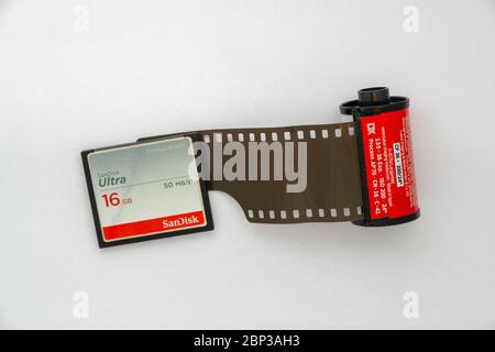 Overhead view of a 16GB SD card next to a slightly unrolled 35mm film cassette Stock Photo