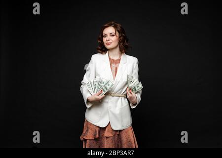 Beautiful young woman after shopping stands with a lot of packages and money in her hands Stock Photo