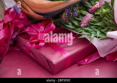 Red gift box with red ribbon, blur office desk background . Red gift box. Closed with red ribbon. Stock Photo