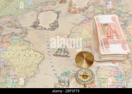 Compass with a bundle of big money are on the map Stock Photo