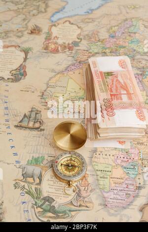 Compass with a bundle of big money are on the map Stock Photo