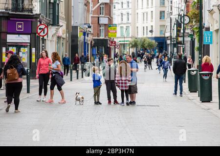 Pedestrians walking through quiet Grafton Street in Dublin City Centre as businesses stay closed & the footfall plummets due to coronavirus pandemic. Stock Photo