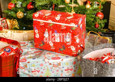 Bags of Christmas presents with a tree blurred in the background Stock Photo