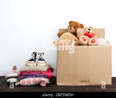 brown cardboard box filled with things and children's toys, concept of moving, volunteering and help Stock Photo