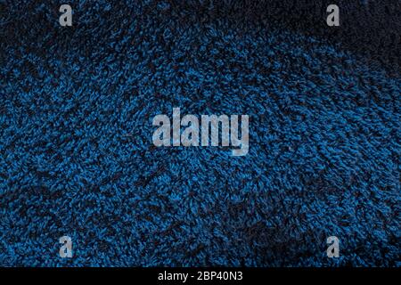 Dark blue colorful pile fleecy fabric towel texture. Macro shot photo of villi. Background with copy space Stock Photo