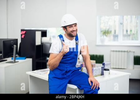 A portrait of a smiling construction site supervisor showing thumbs up Stock Photo