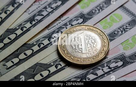 Turkish Lira coin on american dollars banknotes. Concept for currency exchange, international trade and inflation. Macro. Selective focus. Stock Photo