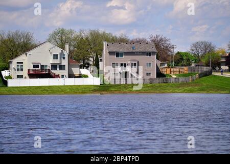 Carol Stream, Illinois, USA. Heavy rains from the night before fill a retention pond an encroach on residential backyards. Stock Photo