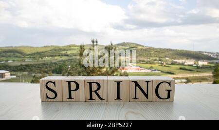 Spring, text on wooden cubes on rusty white painted iron. Stock Photo