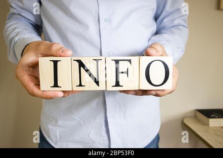 The word info written on wooden cubes held by hand. Close-up. Consept Stock Photo