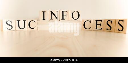It writes the words info, success, work on the cubes on the wooden table. Stock Photo