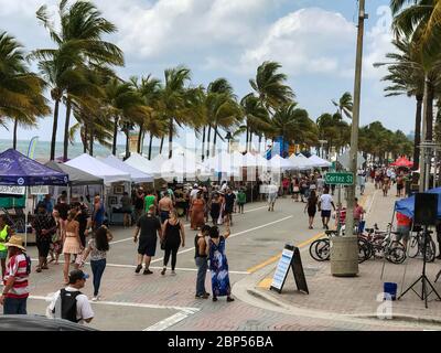 People shop at street vendor tents lined up on Highway A1A at the beach during a Memorial Day festival in Ft. Lauderdale, Florida on May 26, 2019. Stock Photo