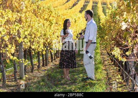 Young couple enjoy a glass of red wine on a picnic in a vineyard in South Australia Stock Photo