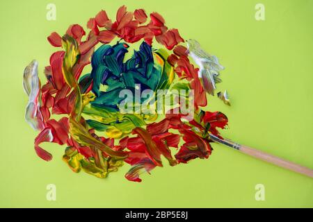 Paint brush with paint splatter against green background Stock Photo