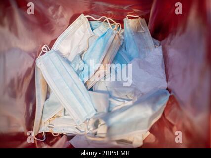 Surgical mask thrown in medical waste bin Stock Photo