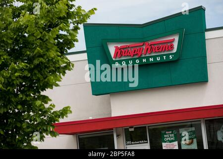 A logo sign outside of a Krispy Kreme Doughnuts restaurant location in Charlottesville, Virginia on May 13, 2020. Stock Photo