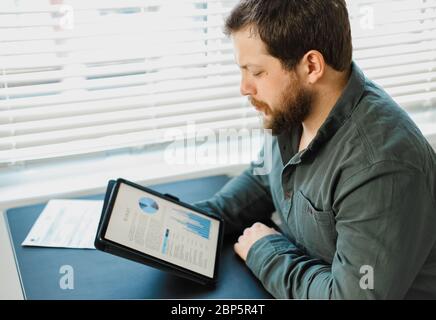 Engineer working with graphs and diagrams on tablet at office. Stock Photo