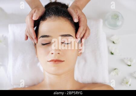 Young woman getting relaxing head massage in beauty salon, view from above Stock Photo