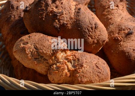homemade oblong crispy bread rolls made of emmer wheat close-up in rustic basket Stock Photo