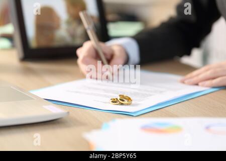 Close up of self employed woman hands divorcing signing papers on a desk at home office Stock Photo