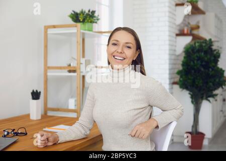 Online business consultation. A businesswoman in casual clothes looks at the camera a video chat conference talking with her partner remotely using Stock Photo
