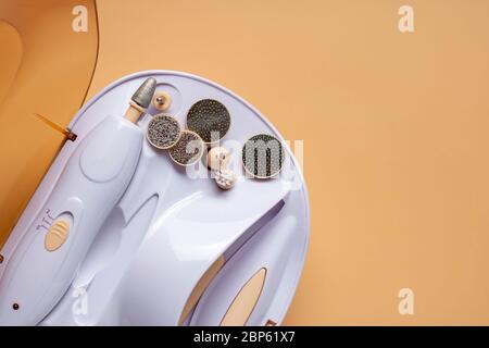Set for home manicure with various nozzles on a beige background. Stock Photo