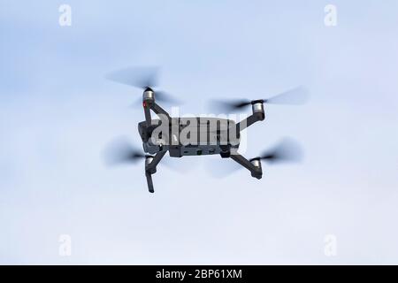 Closeup of a modern quadrocopter with a video camera on a background of clear sky Stock Photo