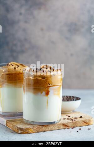 Cold dalgona coffee. Korean trend drink. Drink with cold milk and coffee cream foam in glass glasses. Stock Photo