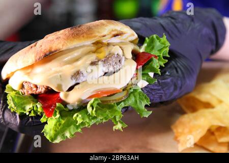 Burger with meat and vegetables. Hot burger in a burning sauce. Stock Photo