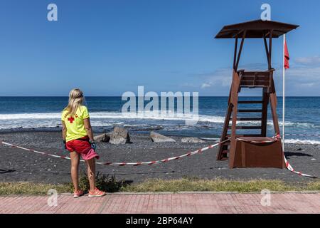 Lifeguard on duty next to lookout tower on Playa Enramada beach during phase one of de-escalation of the Covid 19, coronavirus, State of Emergency, Pl Stock Photo