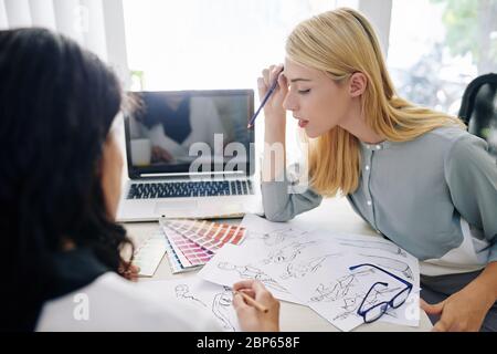 Young female fashion designers working on new collection and choosing color scheme Stock Photo
