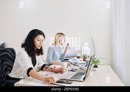 Concentrated UI and UX designers working on project at office desk Stock Photo