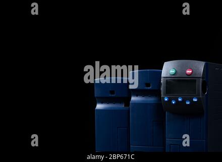 Frequency inverter. Three inverter controller set isolated on black background. Power inverter with run and stop button in green and red. Inverter Stock Photo