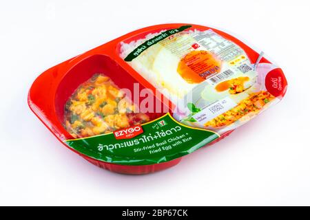 CHONBURI, THAILAND-MAY 15, 2020 : Stir-fried basil chicken+ fried egg with rice in plastic box food package. Microwave food for to go. Ready meals. Stock Photo