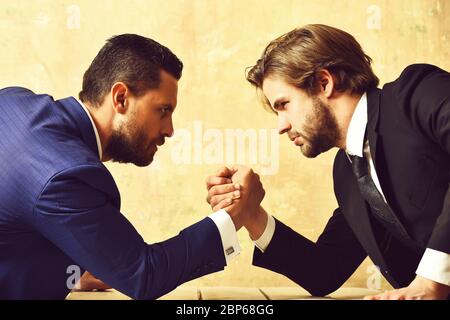 Conflict. Businessmen arm wrestling in suit in office. Stock Photo