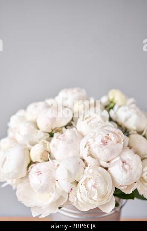 White Odile peonies in a metal vase. Beautiful peony flower for catalog