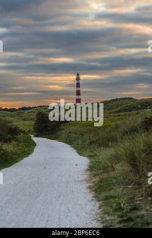 Dune path on the North Sea island of Ameland with a view of the lighthouse Stock Photo