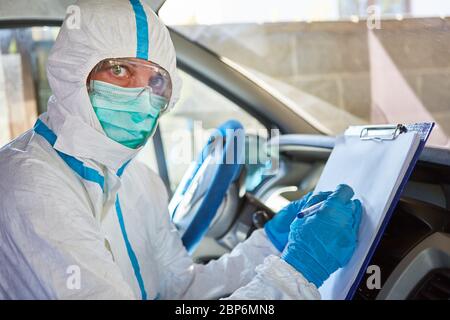 Paramedic as containment scout with list for contact tracking in the ambulance in the case of a coronavirus pandemic Stock Photo