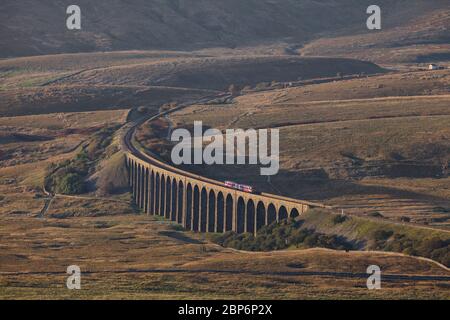 Arriva Northern rail class 158 sprinter train crossing Ribblehead viaduct surrounded by the Yorkshire dales countryside Stock Photo