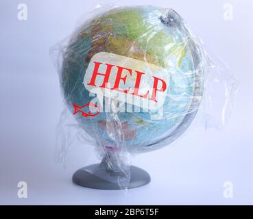 Text Help on speech bubble and icon of fish and Model planet Earth in polyethylene plastic disposable package on blue background. Ecology problems Concept pollution of environment with polyethylene plastic waste World Earth Day Stock Photo