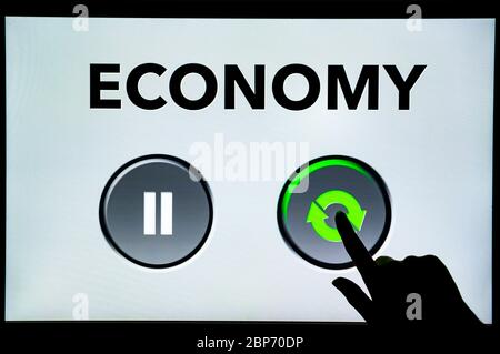 Economy Restart after coronavirus covid pandemic. Hand pressing the green restart button on monitor of computer. The increase to the global economy fr Stock Photo
