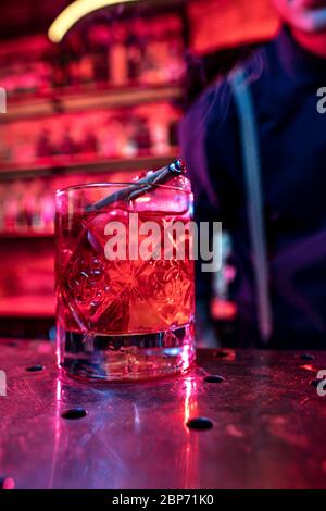Close up of alcoholic cocktail, beverage, drink, prepared by professional barman in multicolored neon light. Entertainment, drinks, service concept. Modern bar, trendy neoned colors, copyspace. Stock Photo