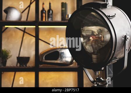Photospotlight in the studio or in the garage. The helmet lies on the shelf in the background. Stock Photo