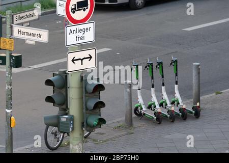 Four fully loaded Lime e-scooters neatly parked by Lime Juicer on the sidewalk in Berlin NeukÃ¶lln at the HermannstraÃŸe corner SilbersteinstraÃŸe for use. Stock Photo