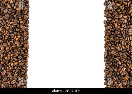 Background made of fresh roasted coffee beans lying flat on a white background with copy space, filled on the sides from top to bottom. Stock Photo