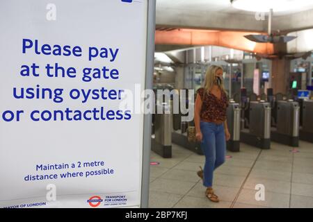 Signage on the London Underground reminds commuters to socially distance during the coronavirus pandemic. Westminster station. May 2020 Stock Photo