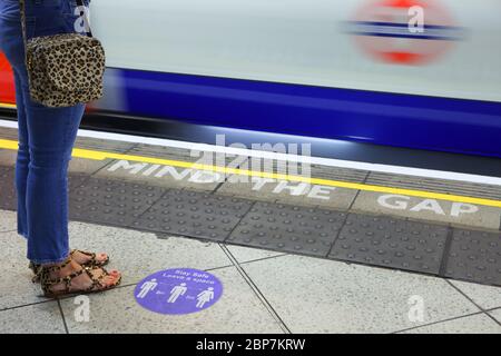 Signage on the London Underground reminds commuters to socially distance during the coronavirus pandemic. Westminster station. May 2020 Stock Photo