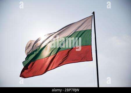 Bulgarian Flag waving wind blowing it and sun illuminating from behind Stock Photo