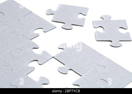 Unfinished jigsaw puzzle pieces on white background. Stock Photo